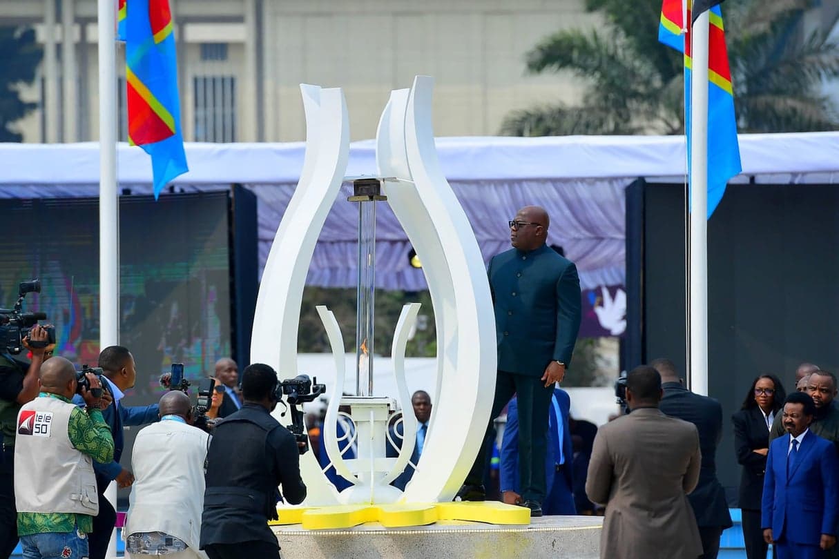 President Félix Tshisekedi stands beside the GENOCOST memorial flame, Congolese flags in the background