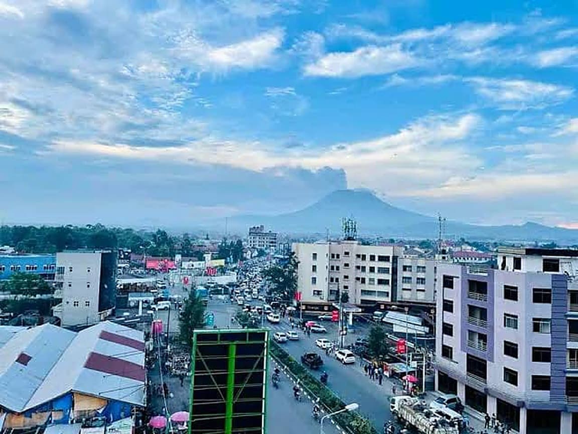 Vue plongeante sur la ville de Goma, le massif du Nyiragongo fumant à l'arrière-plan