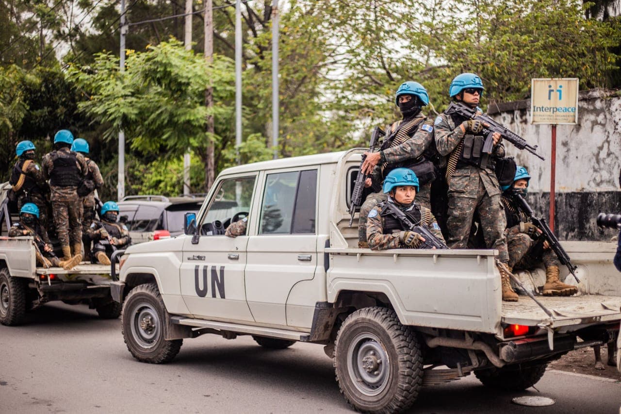 Des Casques bleus des Nations unies, armés, à bord de véhicules tout-terrain marqués « UN » dans une rue de Goma